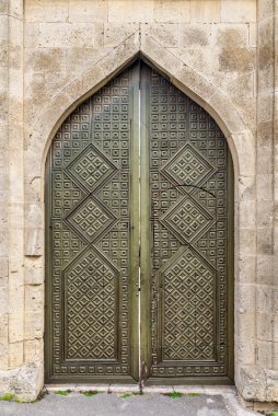 Karmaşık geometrik oymalar içeren çift kapılı süslemeler, tarihi Eski Şehir 'de gururla duruyor, Bakü, Azerbaycan' ın icherisheher 'i bölgelerin mimari güzelliğini ve kültürel mirasını yansıtıyor.