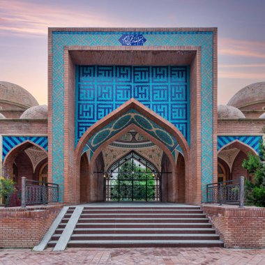 The stunning Imamzadeh Mausoleum in Ganja, Azerbaijan features intricate tile designs. The scene captures the beauty of the structure under a colorful sunset, highlighting its architectural details clipart