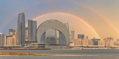 View of the Crescent Development Project in Baku, Azerbaijan, highlighting its unique architecture with a striking rainbow in the background during a clear day clipart