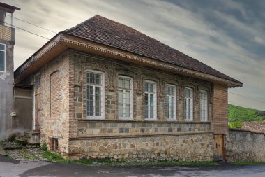 Bu büyüleyici yapıda taş ve tuğla duvarlar, büyük pencereler ve sakin bir kırsal alana yerleştirilmiş ahşap bir çatı karışımı yer alıyor. Çevreleyen yeşillik kırsal cazibesini artırıyor