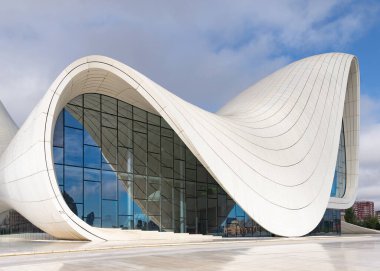 Azerbaycan 'ın Bakü kentindeki Heydar Aliyev Merkezi, mimar Zaha Hadid tarafından yaratılan açık bir gökyüzüne karşı akıcı, dalga esinlenilmiş tasarımıyla çağdaş mimariyi temsil ediyor.