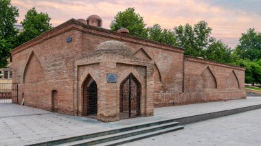 Ganja, Azerbaycan 'da antik bir hamam olan Chokak Hamam, günbatımında yemyeşil bir yeşilliğin ortasında duruyor ve eşsiz mimari özelliklerini ve tarihsel önemini vurguluyor.