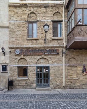 Bakü, Azerbaycan - 4 Mayıs 2024: Icherisheher 'de bulunan Absheron-Sharab OJSC mağazasının tarihi taş mimarisi ve geleneksel tasarım unsurlarının yer aldığı görüntüsü