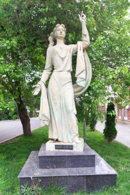 Ganja, Azerbaycan - 13 Mayıs 2025: Heykeltıraş Khanlar Ahmedov tarafından yapılan Sari Gelin heykeli, yeşillikle çevrili ve güzelliğini sergileyen Ganja Devlet Tiyatrosu 'nun yanında zarif bir şekilde duruyor.