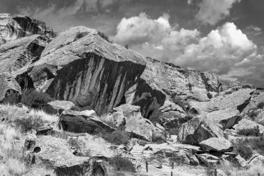 Qobustan, Azerbaycan 'daki engebeli arazinin tek renkli hava manzarası devasa kayaları ve yemyeşil yeşillikleri geçen dolambaçlı bir yolu resmediyor.