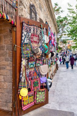 Bakü, Azerbaycan - 4 Mayıs 2024: Tarihi Icherisheher ilçesinde renkli dokuma halılar, çantalar ve diğer geleneksel eşyalar satan bir dükkan