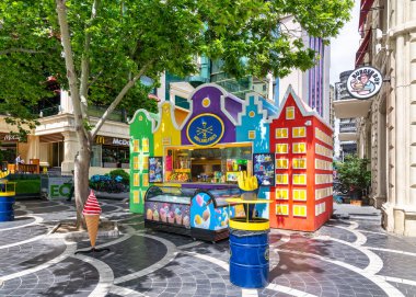 Baku, Azerbaijan - May 5, 2024: A vibrant food kiosk located on Nizami Street prominently displays a Holland Fries sign, showcasing an array of delectable food items clipart