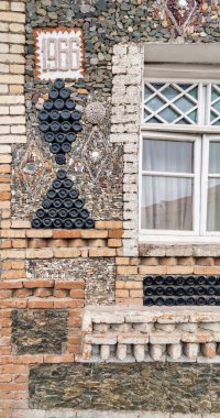 Azerbaycan, Ganja 'daki Şişe Evi' nin cam şişe süslemesi. Ahşap antika pencerenin yanında istiflenmiş şişelerden yapılmış üçgen şekiller.