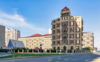 Bakü 'deki 8 Aralık Bulvarı' ndaki eşsiz binaların büyüleyici görüntüsü. Tarihi ve çağdaş mimarinin karışımı açık mavi gökyüzü altında dikkate değer bir şehir manzarası yaratır.