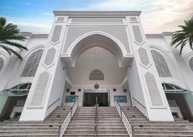 Malezya 'nın Kuala Lumpur kentindeki El-Buhari Vakfı Camii' nin büyük girişi, yemyeşil, karmaşık İslami mimari ortamda, yansıma ve dua için huzurlu bir alan yaratarak kurulmuştur.