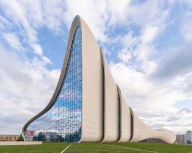 Azerbaycan 'ın Bakü kentindeki ikonik Heydar Aliyev Merkezi, mavi gökyüzüne karşı akışkan, dalga benzeri tasarımıyla modern mimariye sahip. Mimar Zaha Hadid tarafından tasarlandı.