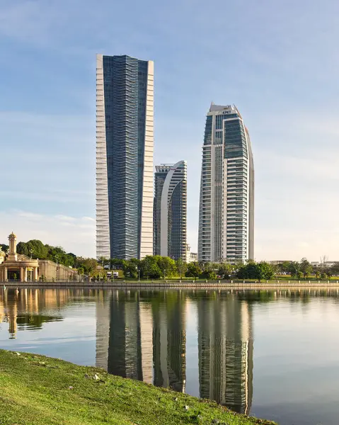 Putrajaya, Malezya - 20 Şubat 2025::: Putrajaya Gölü 'ndeki Seri Gemilang Köprüsü, Menara Usahawan, KKDW ve KPKT hükümet binalarının bir yansıması
