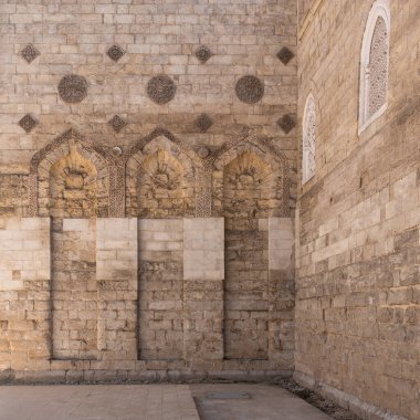 El Zahir Baybarları Camii Mısır 'ın Kahire şehrinde görkemli bir şekilde duruyor ve yumuşak altın saat ışığı altında karmaşık taş işçiliği ve mimari ayrıntılar sergiliyor.
