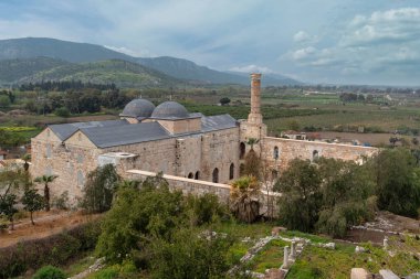 Selcuk, İzmir 'deki Selçuk Bey Camii' nin mimari güzelliği, hindi. Çevresindeki manzaralar, bölgenin tarihsel önemini zenginleştiren sakin bir zemin sağlıyor.