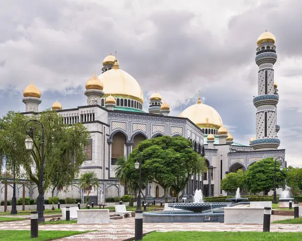 Brunei, Bandar Seri Begawan 'daki Jame Asr Hassanil Bolkiah Camii' nin çarpıcı mimarisi. Altın kubbe renkli bir gökyüzünün altında parlıyor ve huzurlu bir atmosfer yaratıyor.