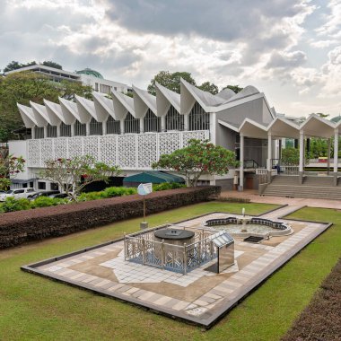 Mescid Negara Ulusal Camisi, Kuala Lumpur, Malezya. Çağdaş İslami mimari katlanmış çatısına, avlusuna, Jam Matahari güneş saatine ve bulutlu bir günde çeşmesine sahiptir.