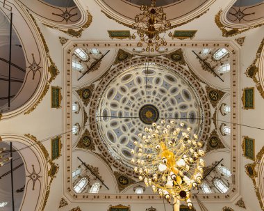 Türkiye 'nin İzmir kentindeki Hisar Camii' nin içine doğru bakan Kubbe, zarif avizelerle çevrili şablonlar ve altın aksanlarla karışık bir şekilde süslenmiş.
