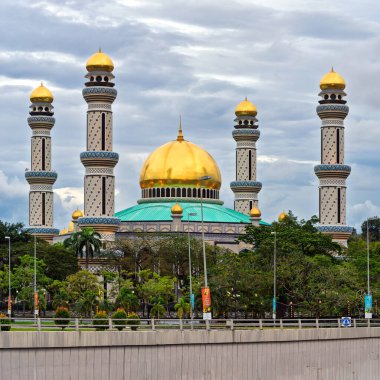 Bandar Seri Begawan, Brunei - 23 Şubat 2025: Jame Asr Hassanil Bolkiah Camii. Büyük camide bulutlu bir gökyüzünün altında altın kubbeler ve minareler yer alıyor.