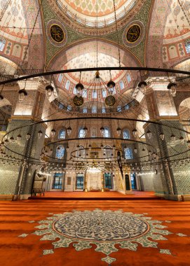 Yeni Cami 'nin iç manzarası, Türk: İstanbul, Türkiye' de Yeni Cami. Zengince dekore edilmiş bir kubbe, asılı avizeler ve duvarlarda ve sütunlarda karmaşık Iznik fayansları var.