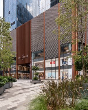 Kuala Lumpur, Malezya - 1 Mart 2025: TRX alışveriş merkezi. Ayırt edici kahverengi cepheli modern mimari, cam pencereler ve açık hava plazası.