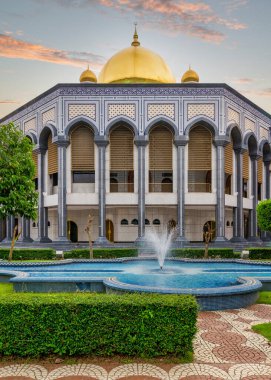 Jame Asr Hassanil Bolkiah Camii, Bandar Seri Begawan, Brunei. Altın kubbeli İslami mimari, karmaşık şablonlar ve gün batımında ön planda bir çeşme.