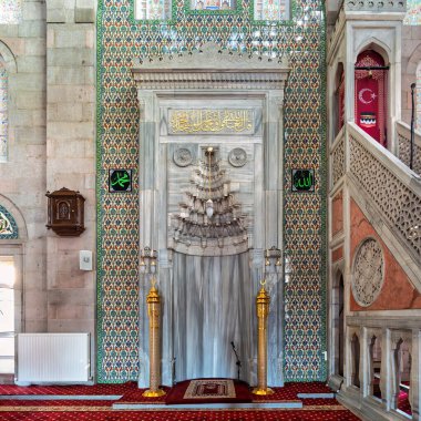 Burunguz Camii 'ndeki mihrab, minbar ve geleneksel Iznik döşemeleri süsleyin: Burunguz Camii, Kayseri, Türkiye. Zengin kırmızı halılar ve altın detaylar