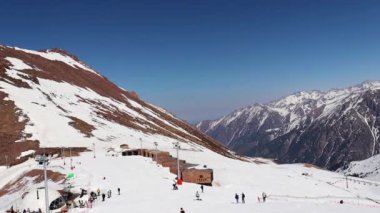 Almaty Kazakistan 25 Mart 2023. Medeo Shymbulak Dağı Tatil Köyü kayakçıları ve snowboardcularla dolu. Kayak merkezi Chimbulak 'ın yamaçlarında kayakçılar. 