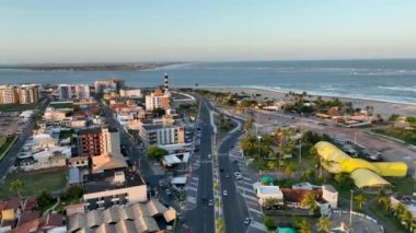 Sergipe Brezilya 'daki Aracaju' da Atalaia Sahili 'nin hava batımı manzarası. Seyahat güzergahı. Gün batımı gökyüzü. Deniz feneri günbatımı silüeti. Sahil şehri manzarası. Turuncu arkaplan.
