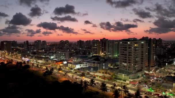 空中の街並みは ブラジルのSergipeでAracajuでカニの散歩道アベニューの日没の風景 目的地へ 日没の空 日没スカイラインの街並み 沿岸都市の風景 オレンジピンクの背景の夕日 — ストック動画