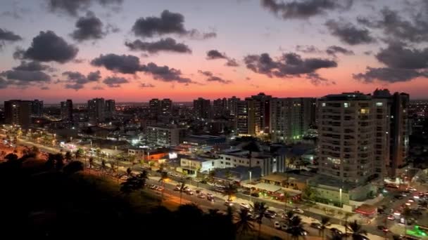 空中の街並みは ブラジルのSergipeでAracajuでカニの散歩道アベニューの日没の風景 目的地へ 日没の空 日没スカイラインの街並み 沿岸都市の風景 オレンジピンクの背景の夕日 — ストック動画
