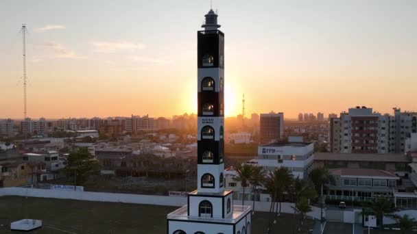 セルゲブラジルのアラカジュにあるアタライア灯台の空中夕日の風景 目的地へ 日没の空 灯台の夕日スカイライン 沿岸都市の風景 オレンジの背景 — ストック動画
