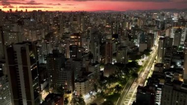 Sao Paulo Brezilya 'da gün batımı. Sao Paulo Brezilya 'da günbatımı gökyüzü manzarası. Renkli gökyüzünün manzarası ve aydınlatılmış kuleler ofis binaları ve gökdelenler. Şehir yaşamı manzarası.