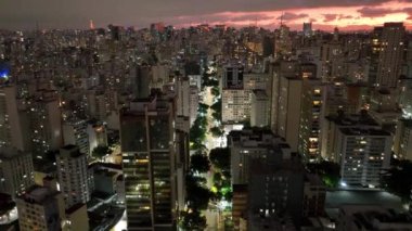 Sao Paulo Brezilya 'da gün batımı. Sao Paulo Brezilya 'da günbatımı gökyüzü manzarası. Renkli gökyüzünün manzarası ve aydınlatılmış kuleler ofis binaları ve gökdelenler. Şehir yaşamı manzarası.