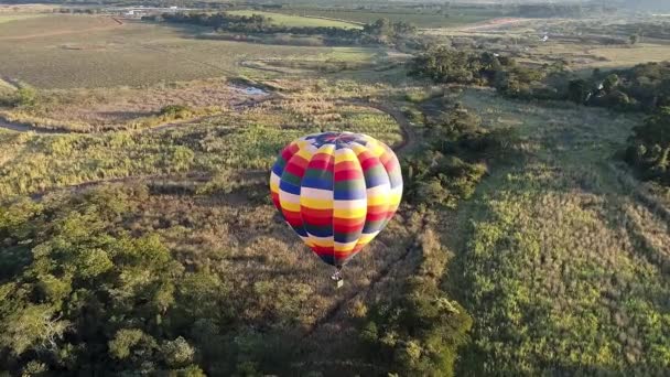 从空中俯瞰乡间风景上孤立的热气球 色彩艳丽的热气球航景 气球升空了乡村风景 体育探险气球的景观 — 图库视频影像