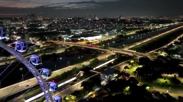 サンパウロ ブラジルの夜景 サンパウロブラジルのダウンタウンでラテンアメリカの主要な観覧車エンターテイメント 遊園地の観覧車でのナイトライフ エンターテイメントアトラクション — ストック動画