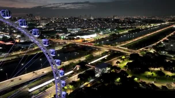 サンパウロ ブラジルの夜景 サンパウロブラジルのダウンタウンでラテンアメリカの主要な観覧車エンターテイメント 遊園地の観覧車でのナイトライフ エンターテイメントアトラクション — ストック動画