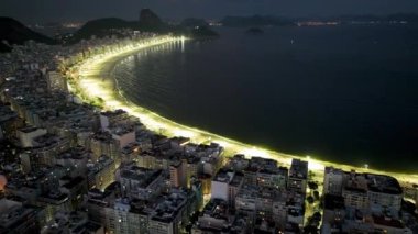 Illuminated Beach At Copacabana Beach In Rio De Janeiro Brazil. Dark Night Life Skyline. Tourism Scenery. Copacabana Beach At Rio De Janeiro Brazil. Dark Illuminated Skyline. Dark Skyline.