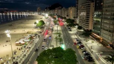 Night Traffic At Copacabana Beach In Rio De Janeiro Brazil. Dark Night Life Skyline. Tourism Scenery. Copacabana Beach At Rio De Janeiro Brazil. Dark Evening Skyline. Dark Skyline.