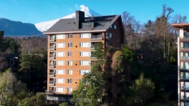 Los Lagos Şili 'deki Pucon' daki binanın arkasındaki volkan. Avrupa Binası. Volkanik Manzara. Turizm arazisi. Pucon Şili. Volkan arka planı. Los Lagos Şili 'deki Pucon' daki binanın arkasındaki volkan..