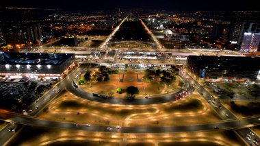 Brezilya 'nın Brasilia şehrinin gece manzarası. Şehir merkezi turizm beldesinde aydınlatılmış meydan ve cadde manzarası.
