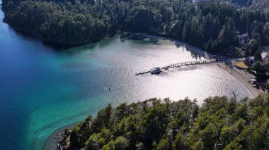 Neuquen Arjantin 'deki Villa La Angostura' da Sunlight Bay Water. Karlı Dağlar. Angostura Köyü. Geçmişe Seyahat. Neuquen Arjantin 'deki Villa La Angostura' da Güneş Işığı Koyu Suyu.