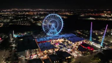 Florida, Orlando 'da dönme dolabı aydınlatmış. Renkli dönme dolap. Aydınlanmış Şehir. Gece Hayatı Manzarası. Florida 'da, Orlando' da Dönme dolabı aydınlatmış..