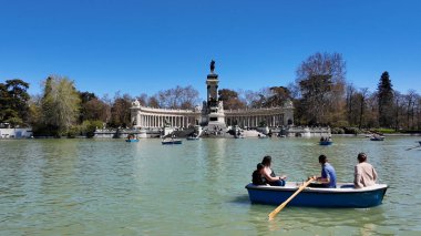Madrid Madrid 'deki El Retiro Parkı İspanya Topluluğu. Ortaçağ Anıt Sahnesi. Doğa Park Peyzajı. Madrid İspanya Topluluğu 'nda Madrid. Göl kıyısındaki tekneler. Güzel Skyline.