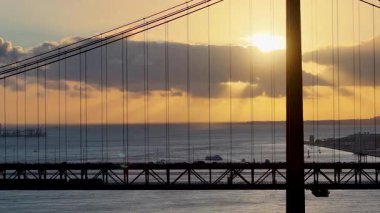 Lizbon 'daki Lizbon Bölgesi' nde 25 Nisan Köprüsünde Günbatımı Gökyüzü. Şehir merkezinde gün batımı. Freeway Yolu Manzarası. Portekiz Lizbon 'da 25 Nisan Köprüsü. Demiryolu Sahnesi.