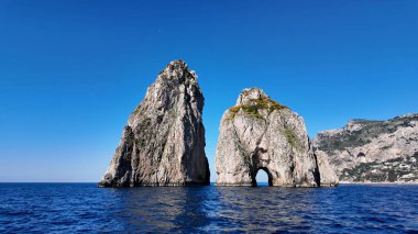 Napoli, Capri 'deki Faraglioni Adası. Plaj manzarası. Dev Uçurumlar Sahnesi. Napoli, Capri 'deki Faraglioni Adası. Napoli Körfezi, Skyline. Akdeniz kıyısı. Capri Adası Manzarası.
