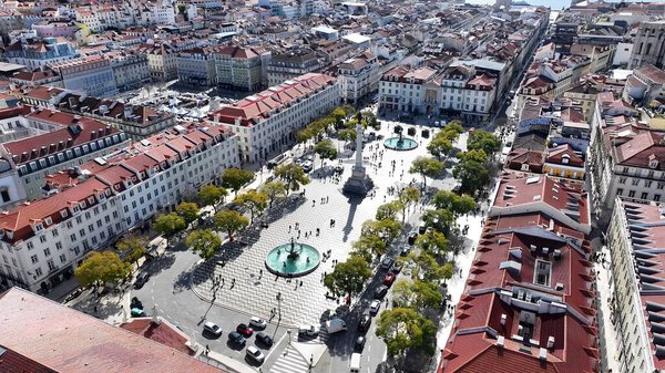 Dom Pedro Iv Square In Lisbon Portugal. Aerial View Of A Bustling City With High-Rise Buildings And Traffic. Metropolitan Landscape Skyscrapers Beautiful. Metropolitan Urban. Lisbon Portugal.
