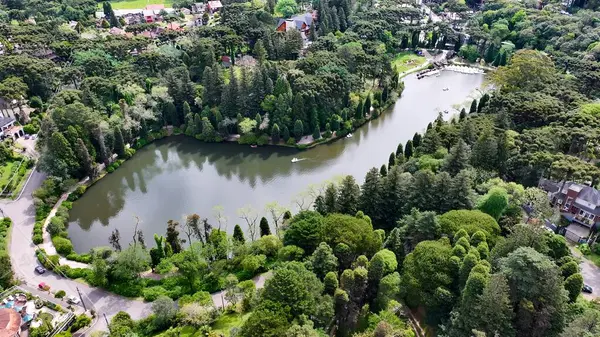 Negro Lake In Gramado Rio Grande Do Sul Brazil. İnsansız hava aracı, etrafı gür ağaçlarla çevrili kaldırımlı bir bahçe yakalıyor. Metropolitan Manzara Gökdelenleri. Güzel. Metropolitan Şehir.