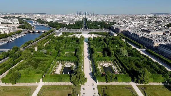 Des Champs Elysees Bulvarı, Fransa, Paris. İnsansız hava aracı, etrafı gür ağaçlarla çevrili kaldırımlı bir bahçe yakalıyor. Şehir merkezinde Gökyüzü Bulutları. Şehir merkezinin dışında. Ünlü..