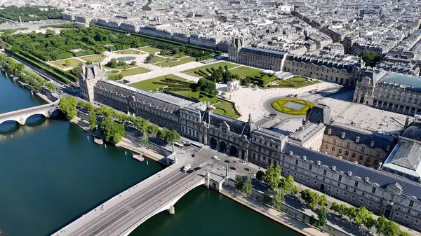 Paris 'teki Louvre Müzesi Ile De France. İnsansız hava aracı, etrafı gür ağaçlarla çevrili kaldırımlı bir bahçe yakalıyor. Metropolitan Peyzaj Ticari Binası Çarpıcı. Metropolitan Atılgan Kasabası.