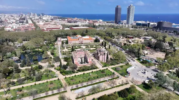 Katalonya 'nın Barselona bölgesindeki Ciutadella Parkı. İnsansız hava aracı, etrafı gür ağaçlarla çevrili kaldırımlı bir bahçe yakalıyor. Endüstriyel Peyzaj Ticari Binası Güzel.